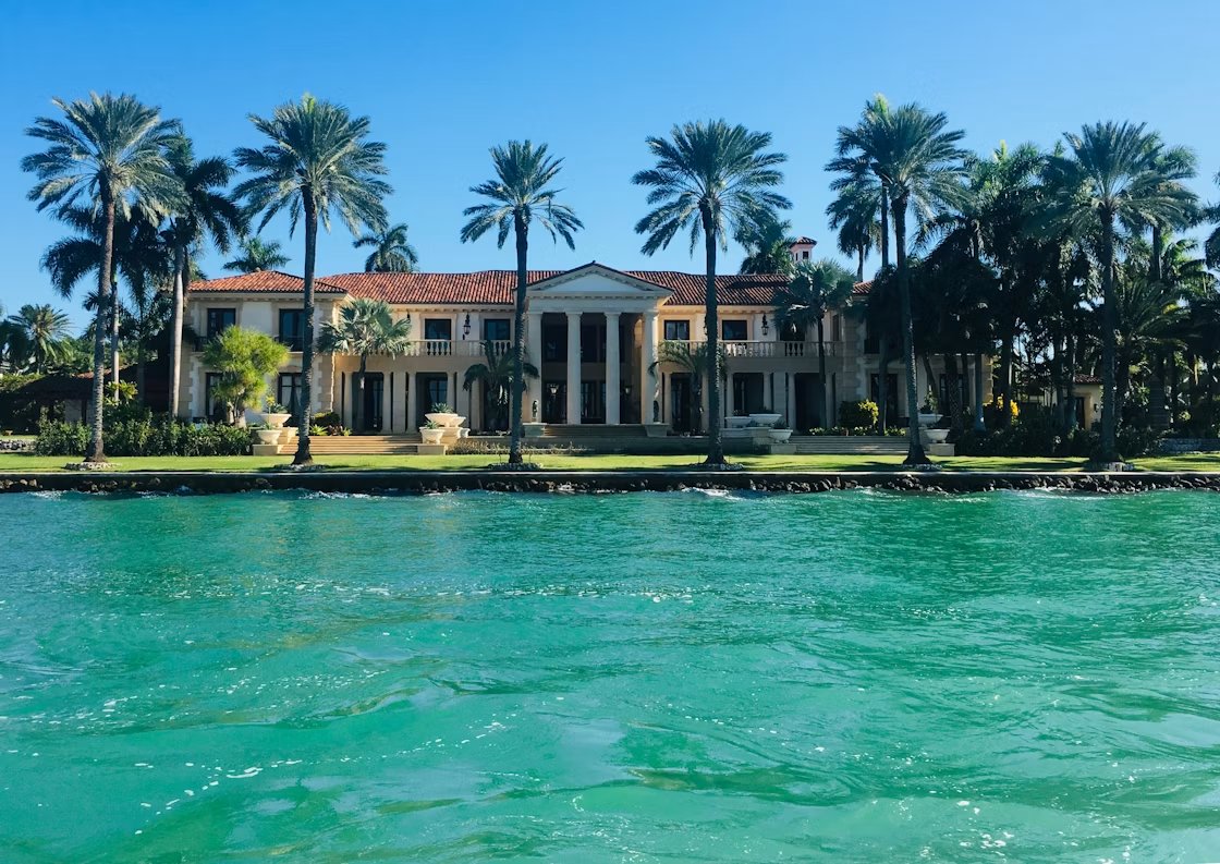 Waterfront Florida mansion with palms seen from the water